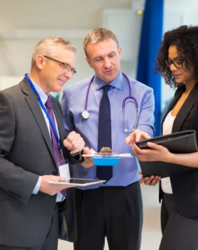 Imagem de um médico, um homem administrador e uma mulher administradora conversando